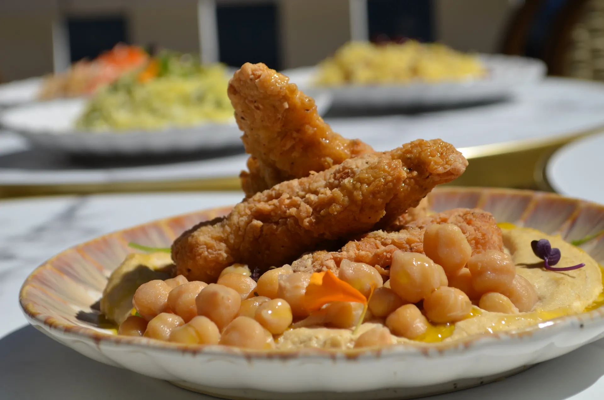 Crispy chicken on hummus with chickpeas